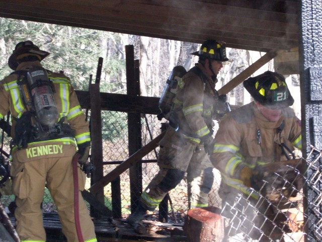 Firefighters Alan Kennedy, Bill Hirthler, and Lonz Brown overhauling a shed fire on Lees Bridge Road.